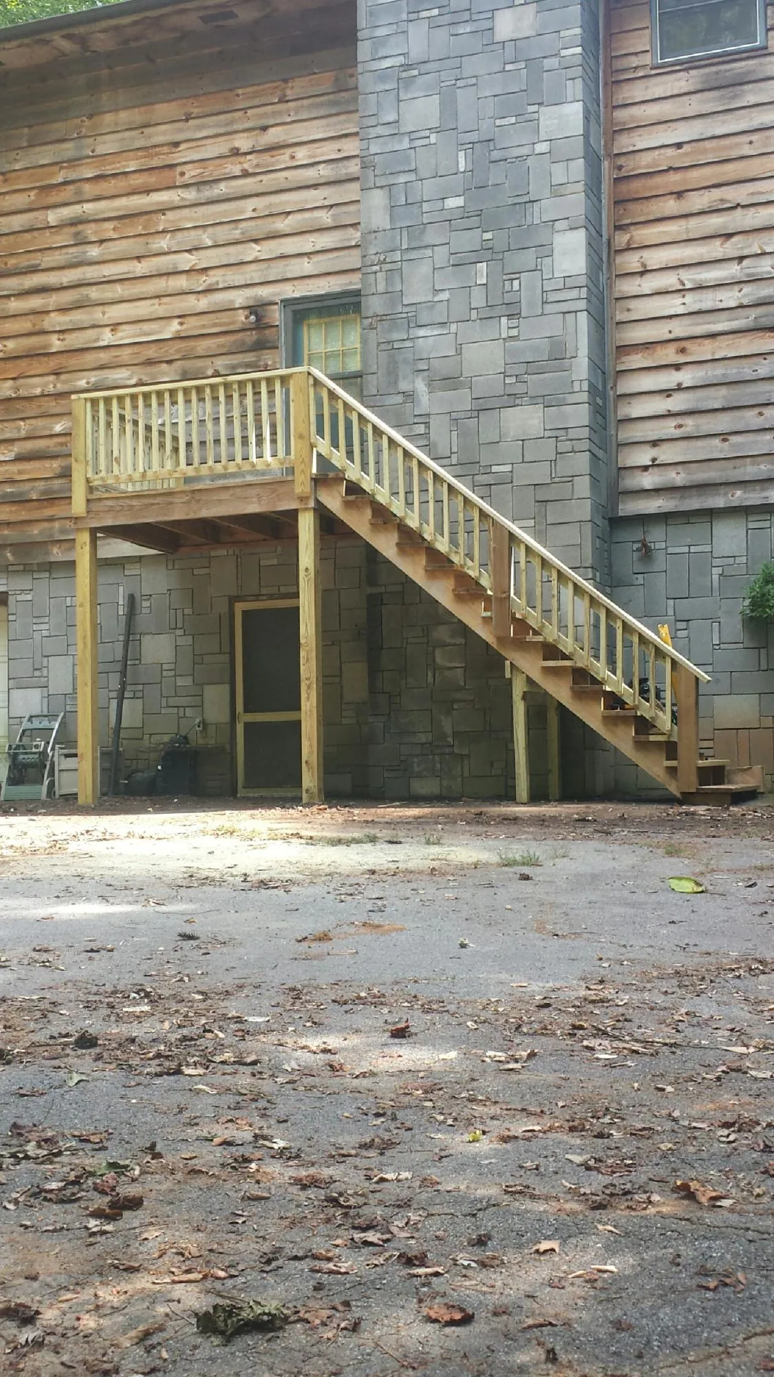 New pressure treated deck and stair landing on a log home in Amherst